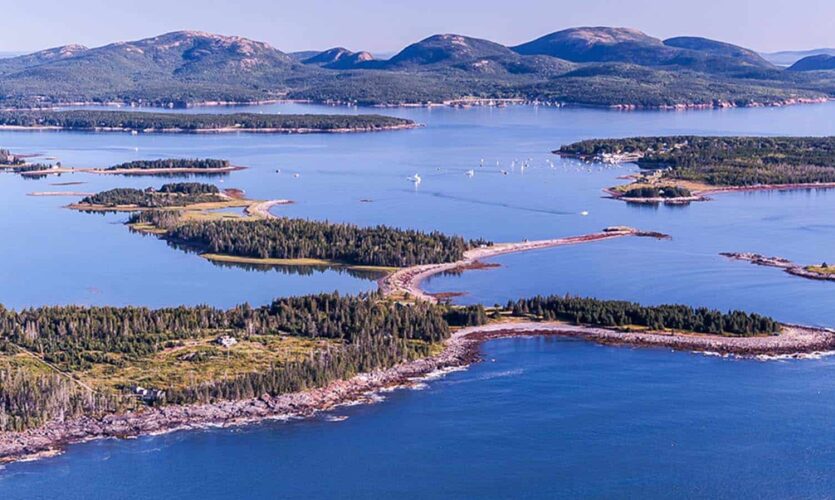 Aerial view of the Cranberry Islands with the hills of Acadia National Park in the background.