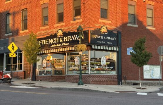 FandB Sunlit corner of brick building housing French & Brawn Marketplace.