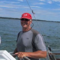 James Bennett at the wheel of his sailboat.