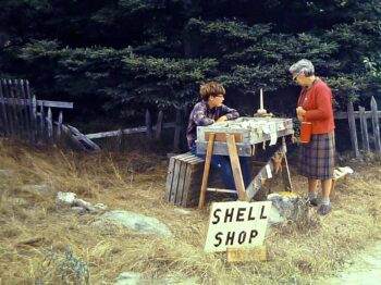 boy selling shells to an older woman