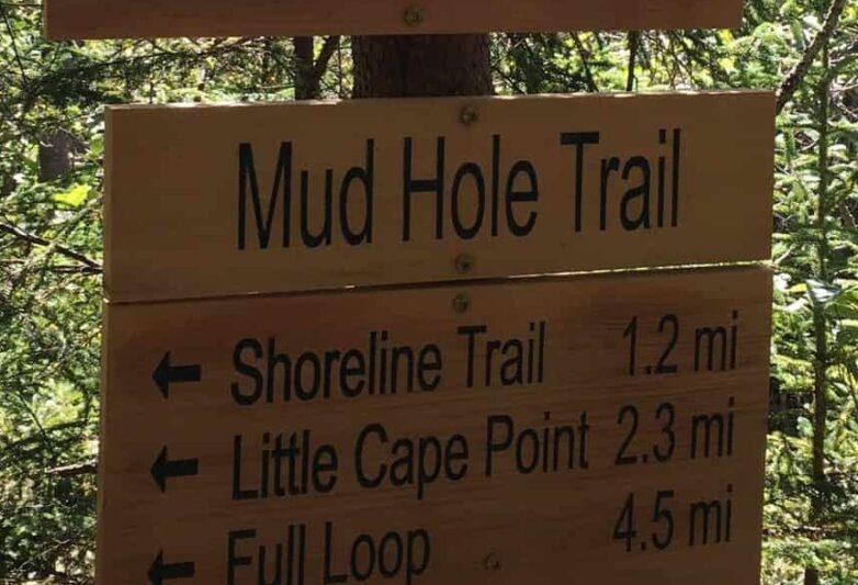 Rustic wooden Mud Hole Trail sign showing distances to points along the trail.