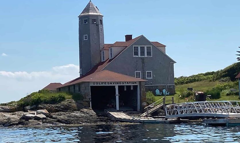 Old Coast Guard rescue station with boat house and ramp leading to the water.