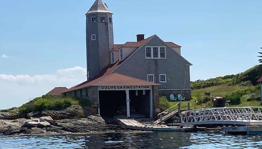 Old Coast Guard rescue station with boat house and ramp leading to the water.