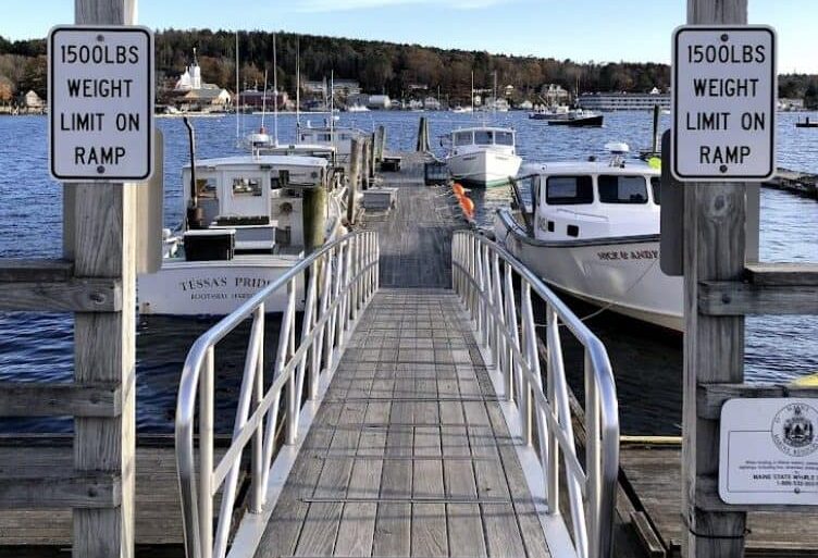 Long ramp leading down to dock with lobster boats tied to each side.