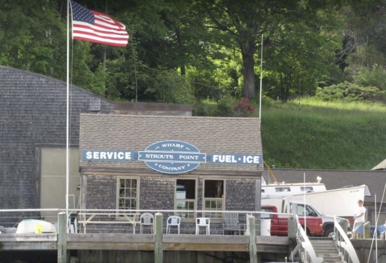 Small building on dock with American flag flying next to it.